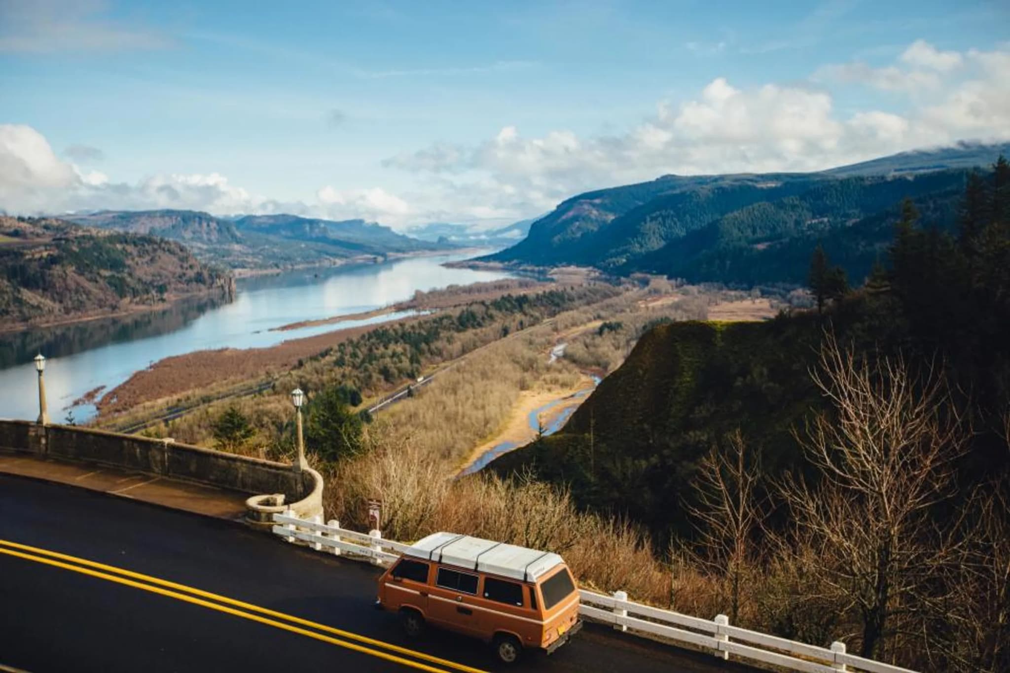 An open road curving along a mountain lake